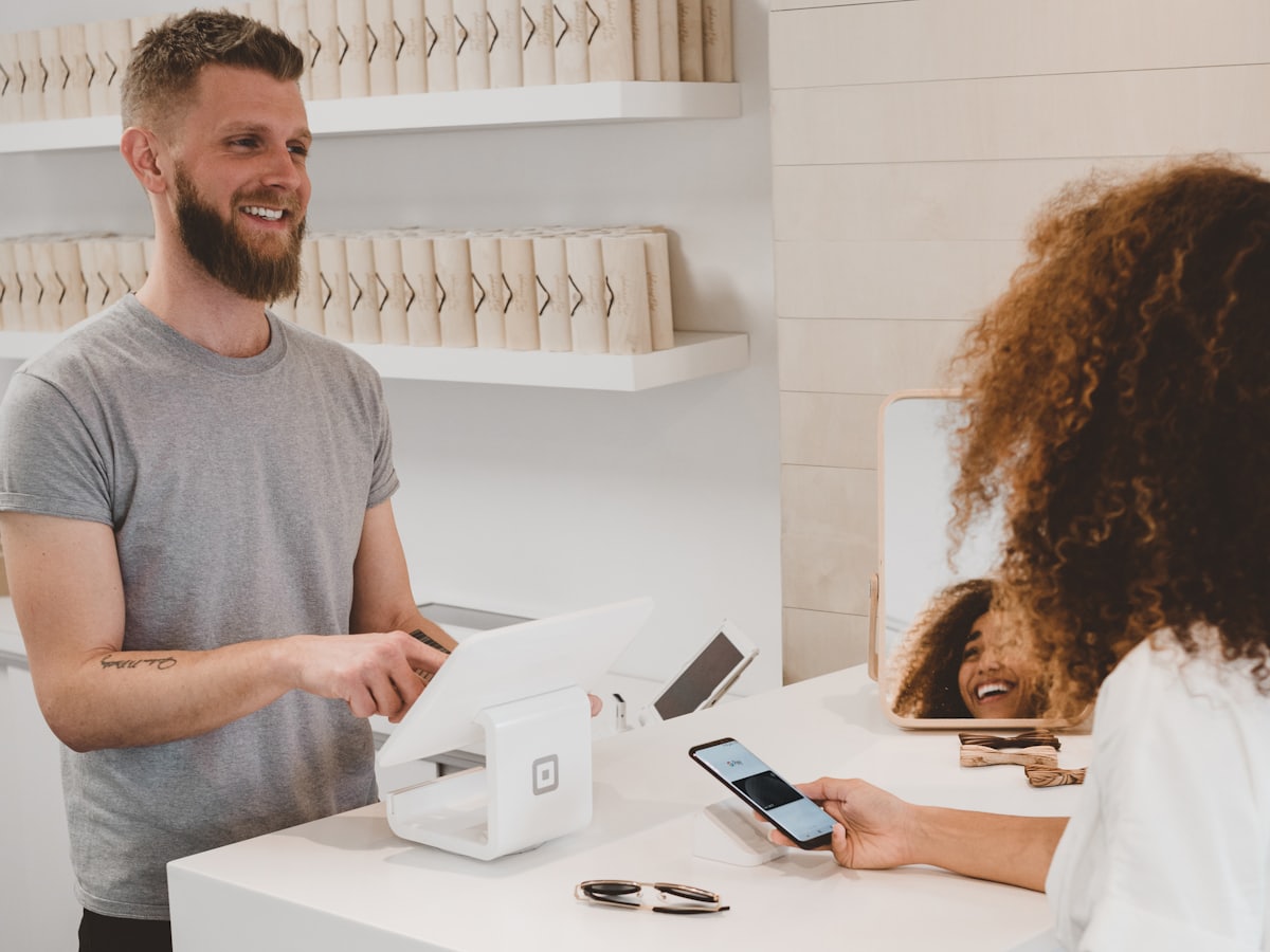Cliente pagando con el móvil en el mostrador de una tienda
